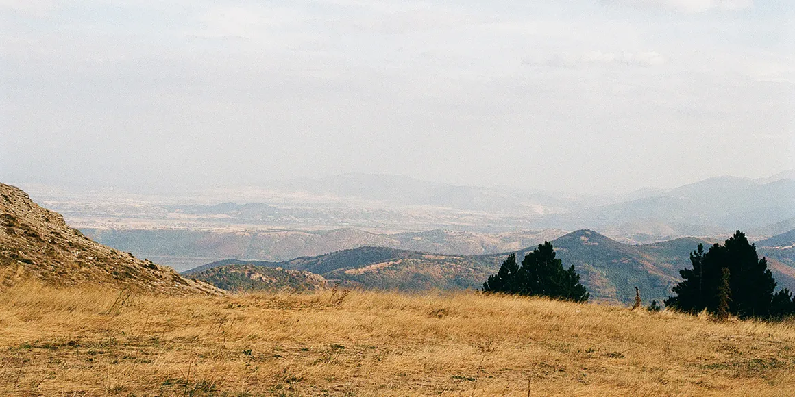 Website hero banner depicting a countryside in Greece